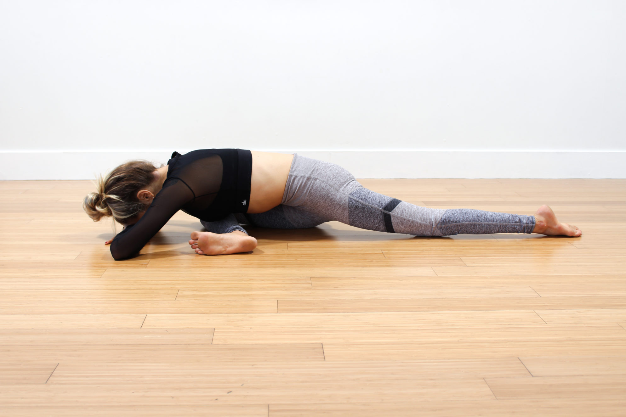 Yogi Practicing Pigeon Pose aka Eka Pada Rajakapotasana in a Yoga Room